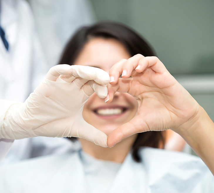 smiling girl holding hands in shape of heart