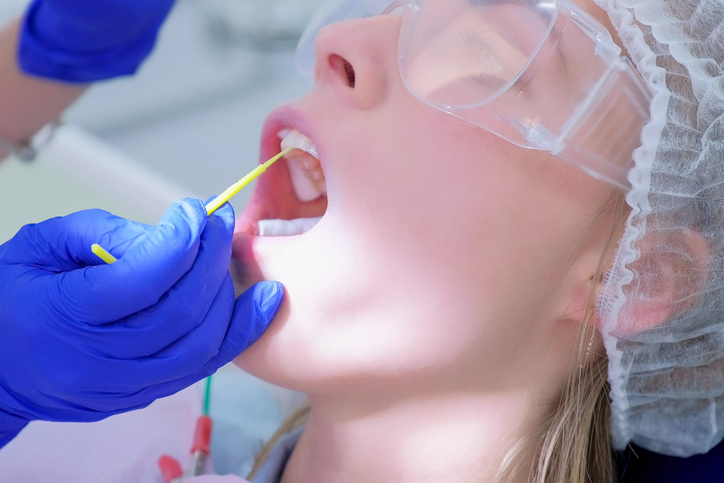 Patient having fluoride applied to her teeth during her dental cleaning