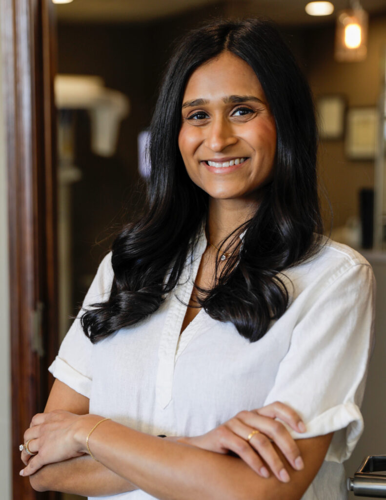 Dr. Patel poses with crossed arms and smiles for a picture