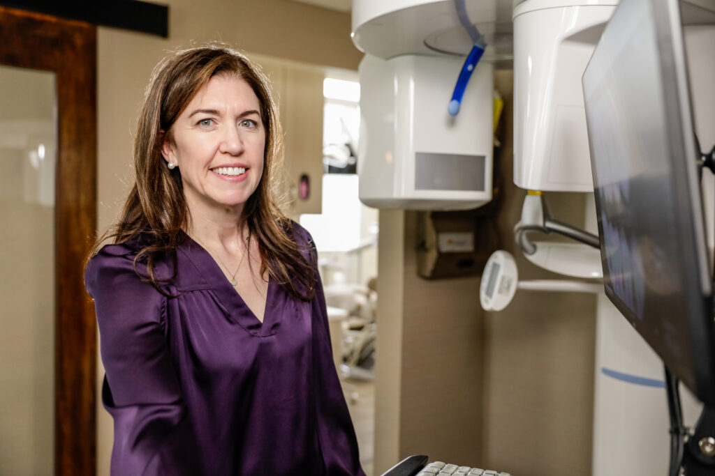 Dr. Hadley Thurmon standing next to a scanner with a purple dress shirt.