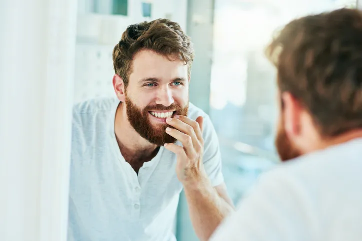 Man checking out his teeth in the mirror